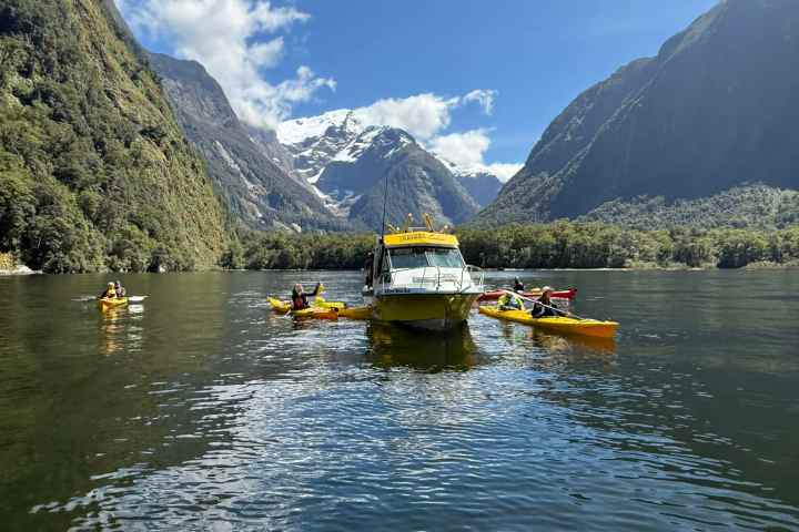 Kayakers surrounded by mountains and a clear sky.